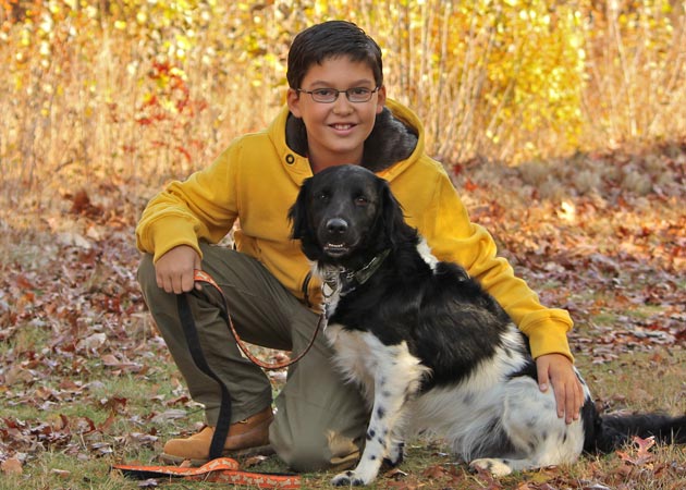 Capturing the closeness of a boy and his dog as they walk through Beebe Meadow in Wellesley MA by Echo Cove Photography