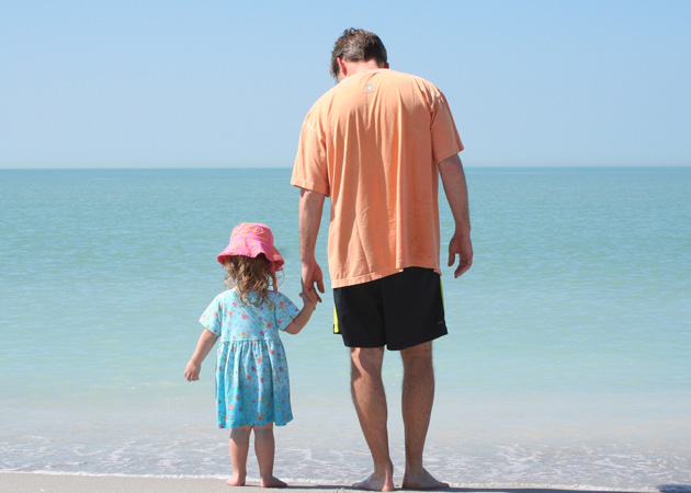 Capturing the closeness of a girl and her father as they explore the shoreline of a deserted beach by Echo Cove Photography