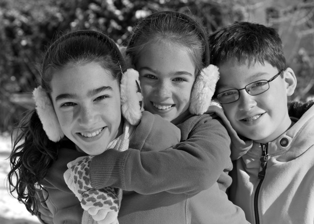 Capturing the closeness of two girls and a boy playing together in the winter in Wellesley MA by Echo Cove Photography